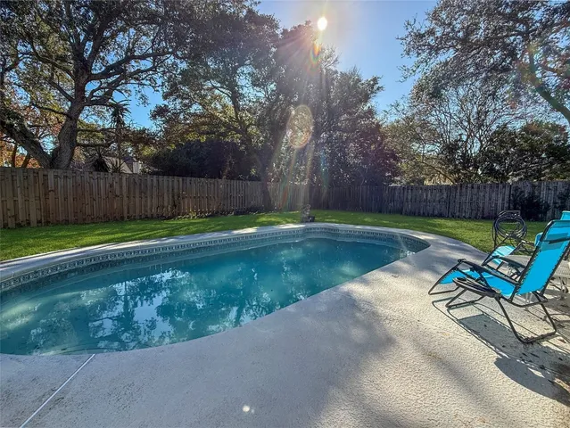 a view of a backyard with furniture and trees