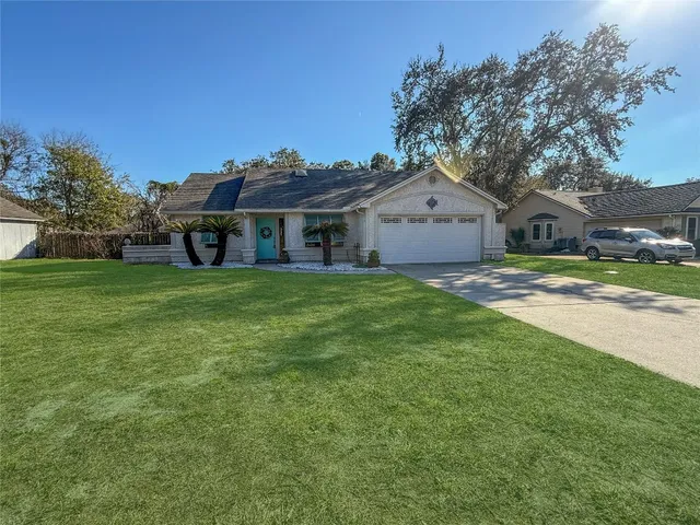 a view of a house with a big yard and large trees