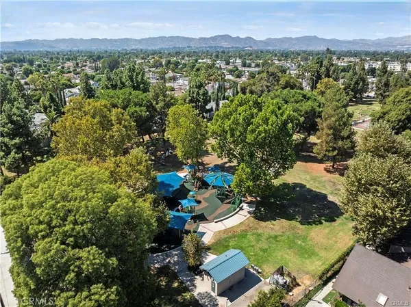 an aerial view of residential house with outdoor space and trees all around