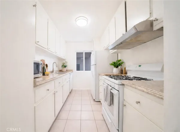 a kitchen with stainless steel appliances granite countertop white cabinets a stove top oven with wooden floor