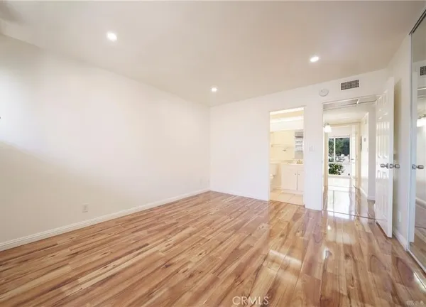 a view of empty room with wooden floor