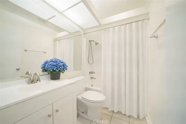 a bathroom with a sink a toilet and shower curtain