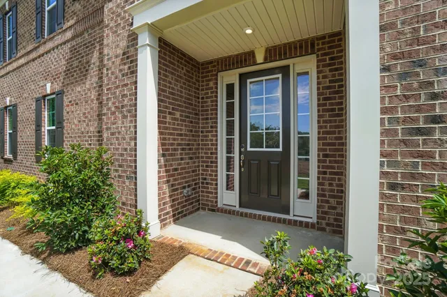 a view of a hallway with wooden floor and entryway