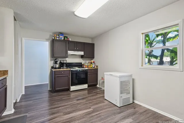 a kitchen with a refrigerator and a stove top oven