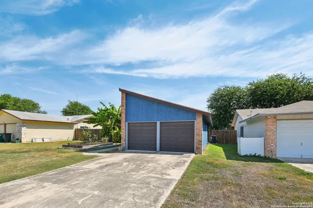 front view of a house with a yard and a garage