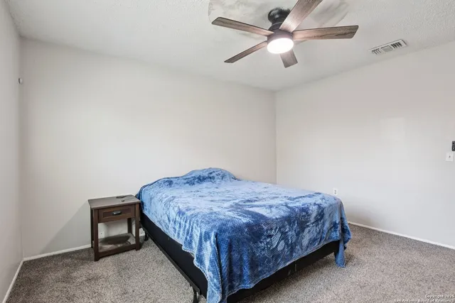 a bedroom with a bed and a ceiling fan