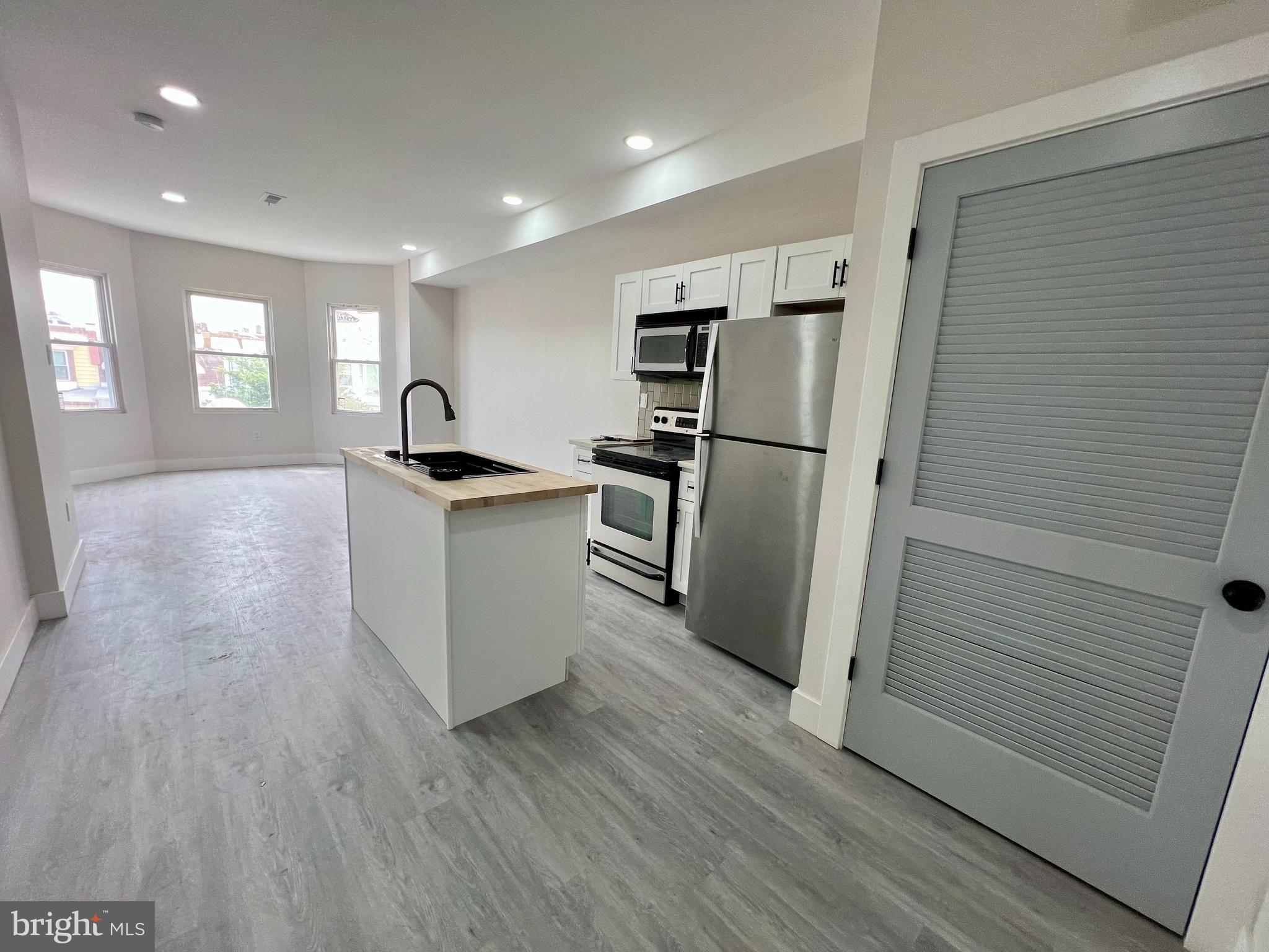 a kitchen with granite countertop a refrigerator and a sink
