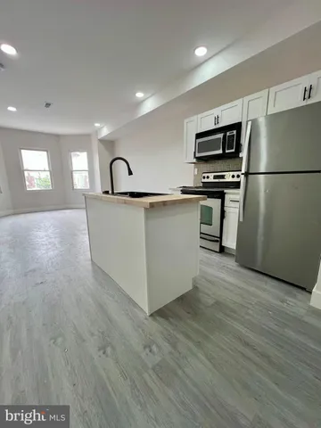 a kitchen with stainless steel appliances a refrigerator microwave and sink