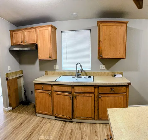 a kitchen with a sink cabinets and a wooden floor