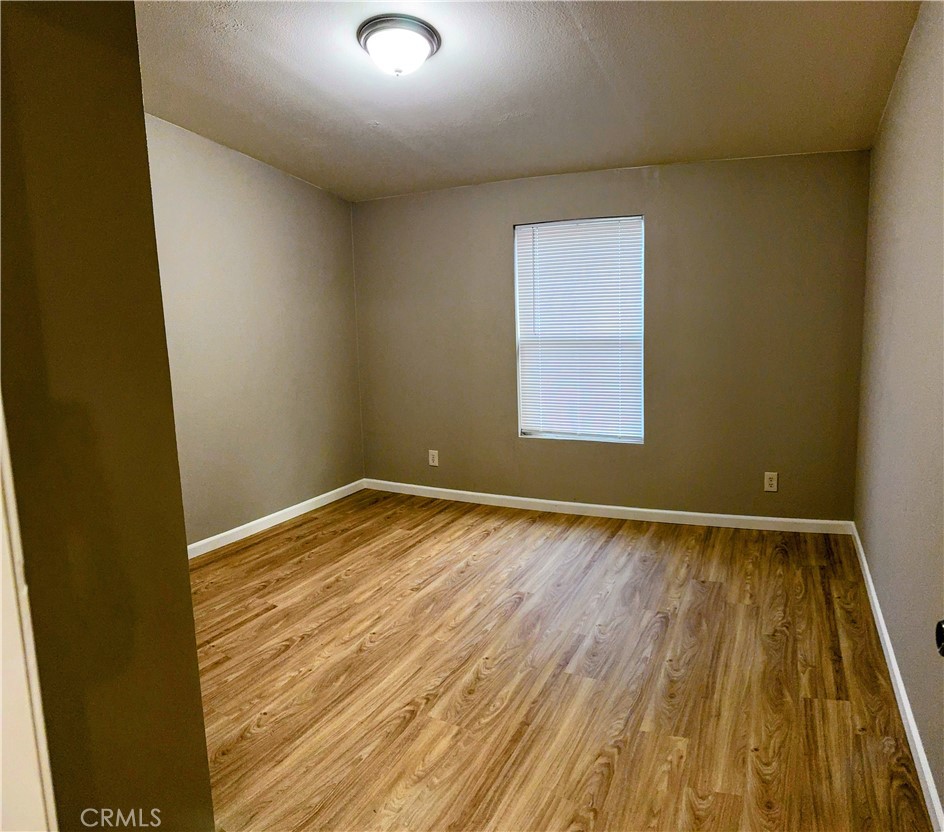 3181 Springe Street Nice, CA 95464 - Photo 6 of 14 an empty room with wooden floor and windows