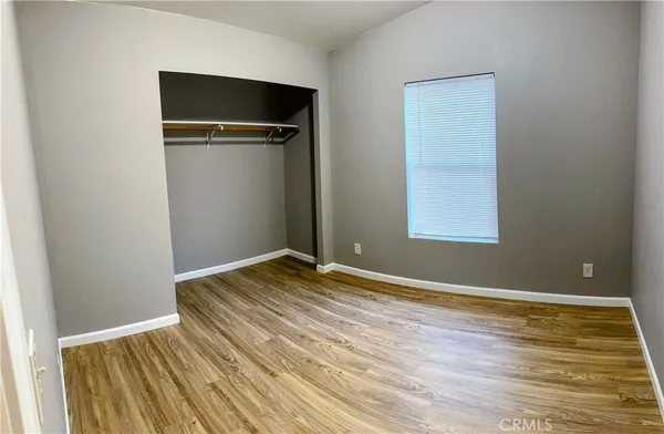 an empty room with wooden floor and closet