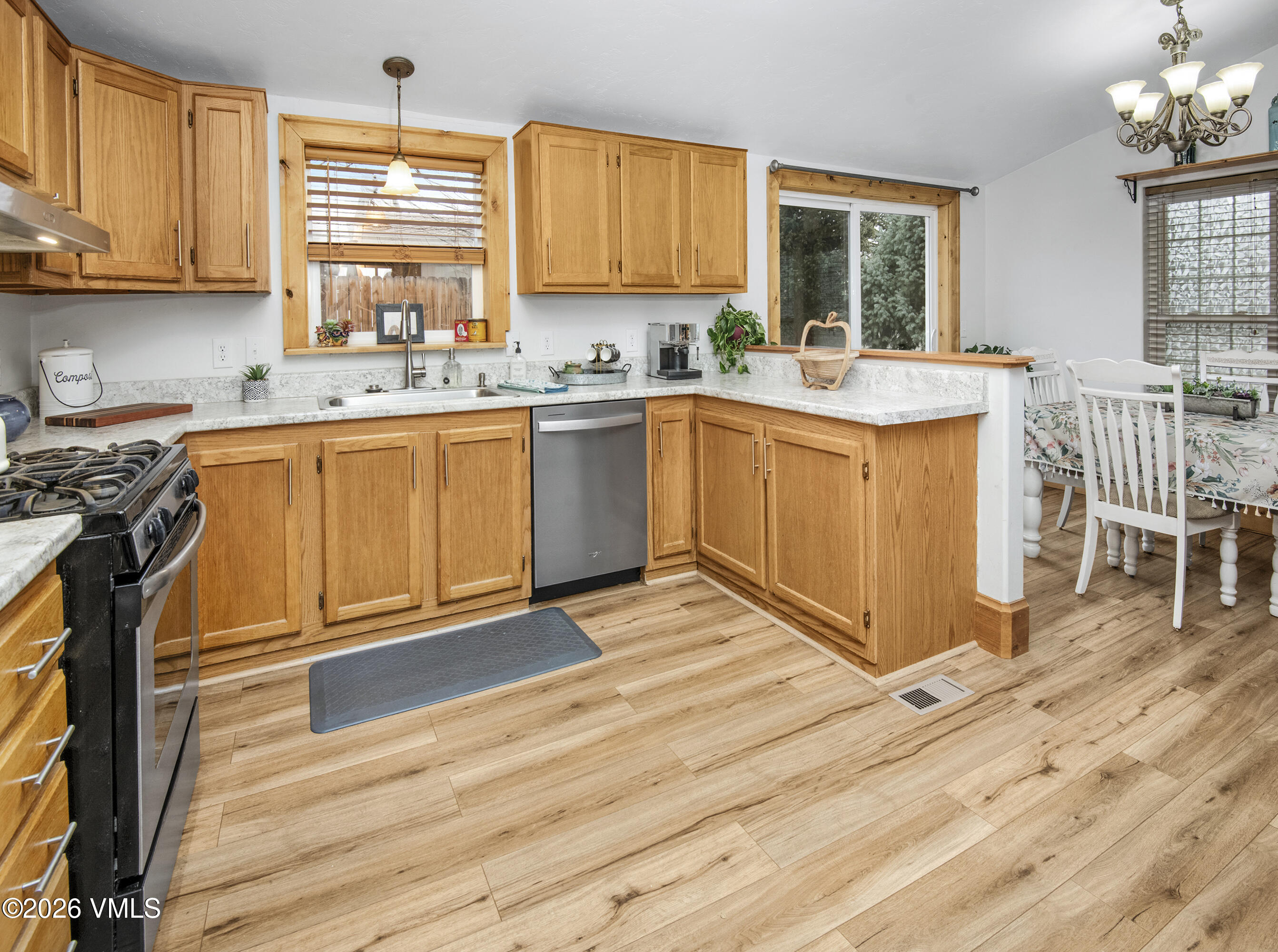 a kitchen with granite countertop a stove a sink and white cabinets