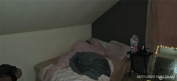 a bed sitting in a bedroom next to a lamp