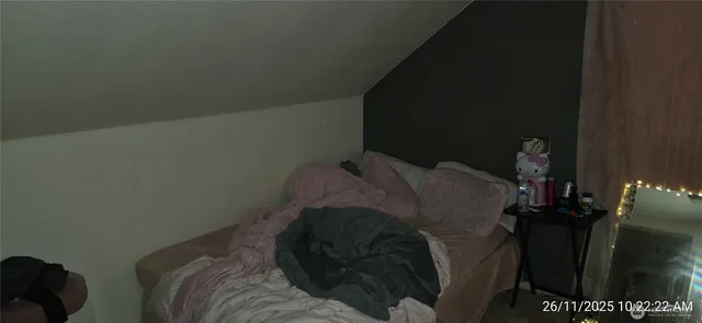 a bed sitting in a bedroom next to a lamp