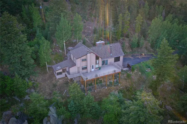 an aerial view of a house with yard and green space