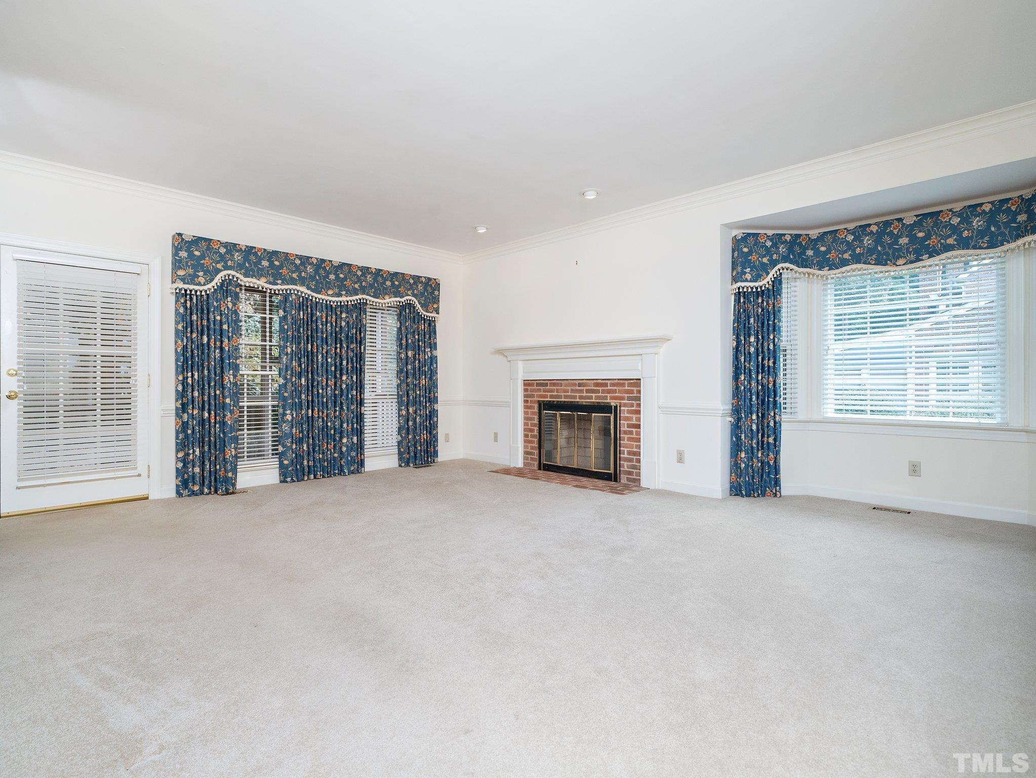 417 Weathergreen Drive Raleigh, NC 27615 - Photo 13 of 37 an empty room with windows and fireplace