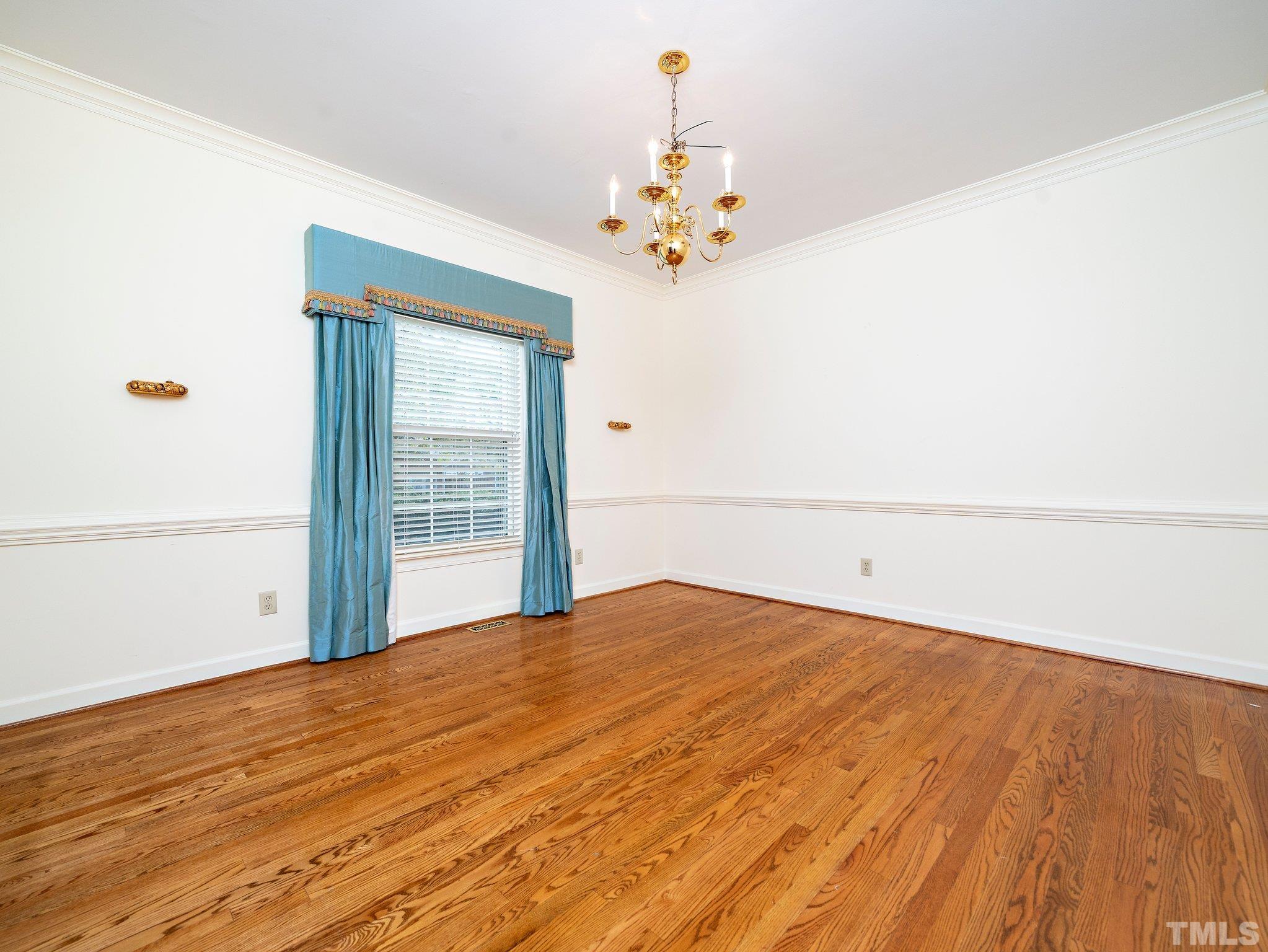 417 Weathergreen Drive Raleigh, NC 27615 - Photo 6 of 37 a view of a bedroom with wooden floor and chandelier