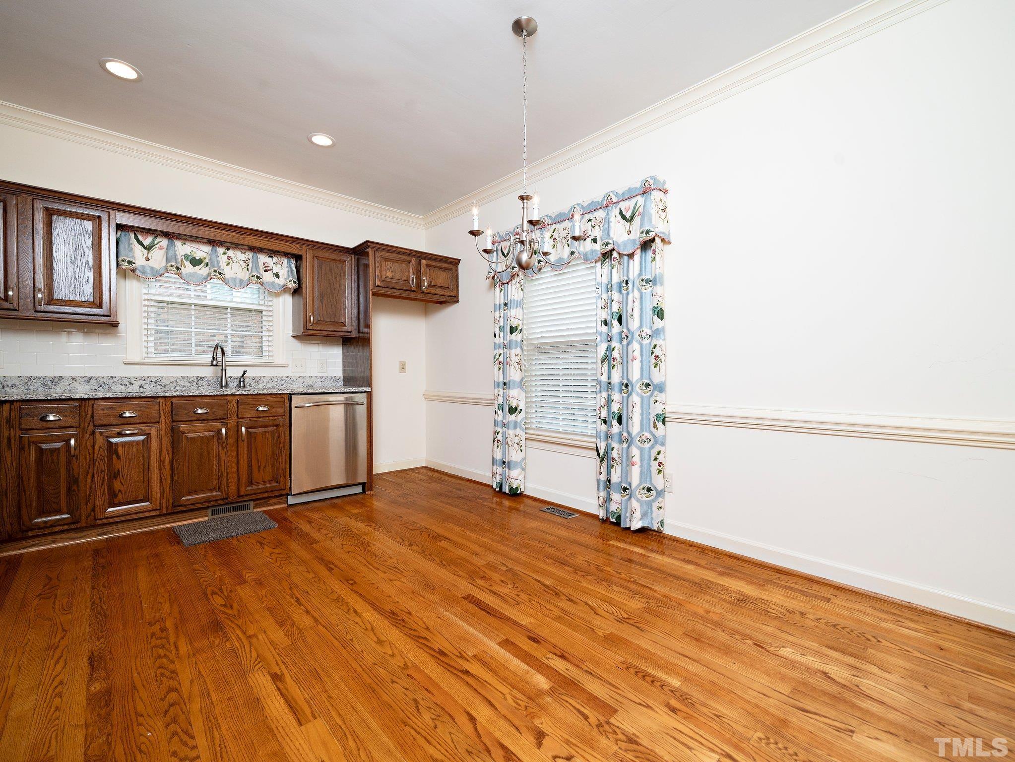 417 Weathergreen Drive Raleigh, NC 27615 - Photo 8 of 37 a view of kitchen with empty room and wooden floor