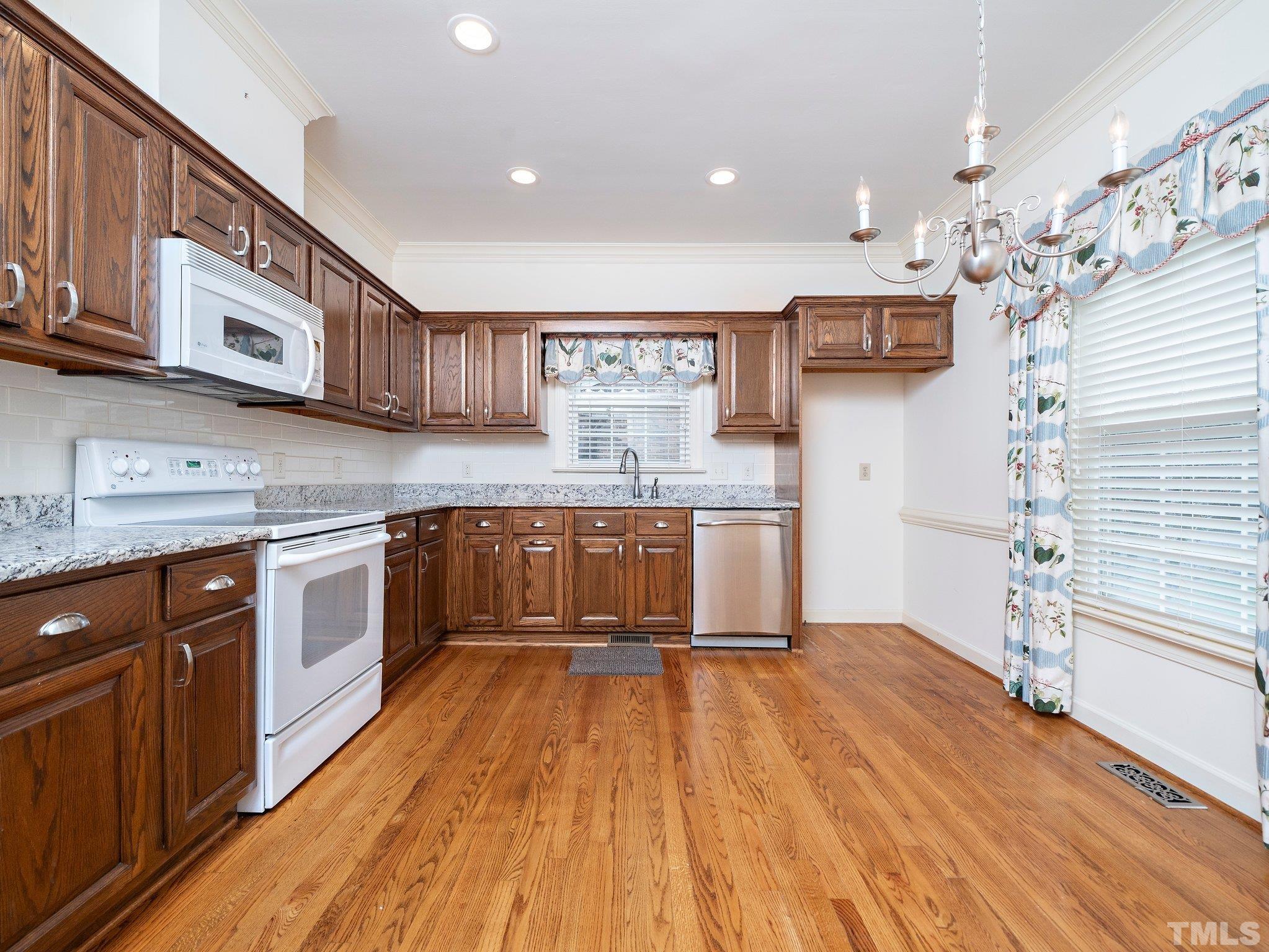 417 Weathergreen Drive Raleigh, NC 27615 - Photo 9 of 37 a large kitchen with stainless steel appliances granite countertop a stove and cabinets