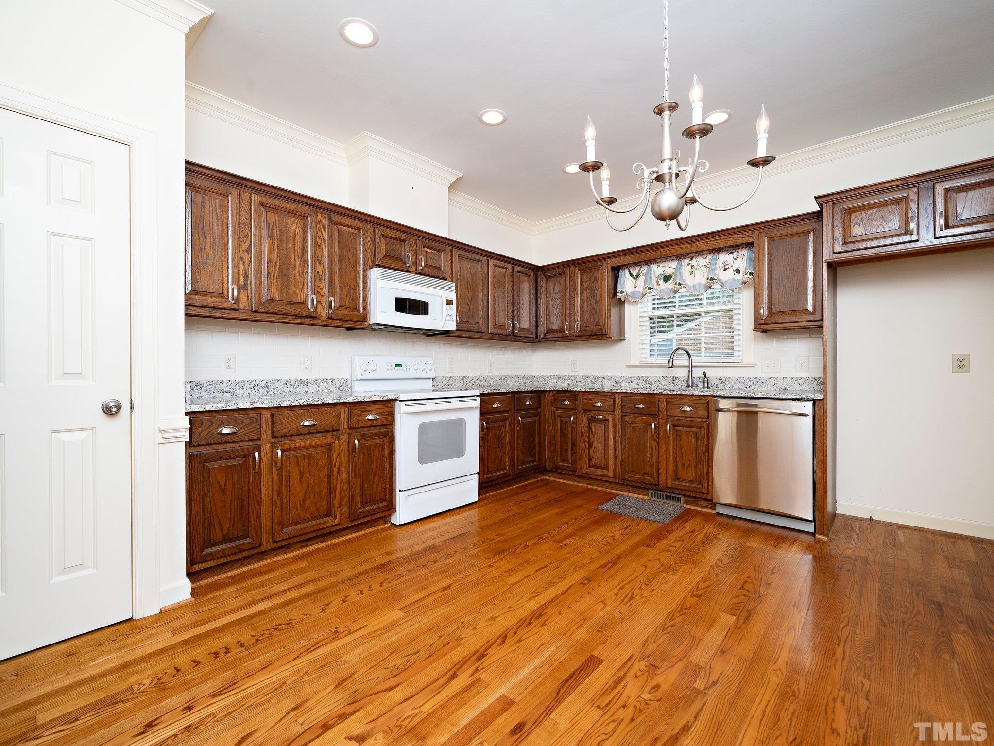 417 Weathergreen Drive Raleigh, NC 27615 - Photo 10 of 37 a kitchen with stainless steel appliances granite countertop a stove a sink dishwasher and a refrigerator with wooden floor