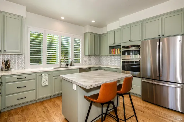 a kitchen with appliances cabinets and wooden floor