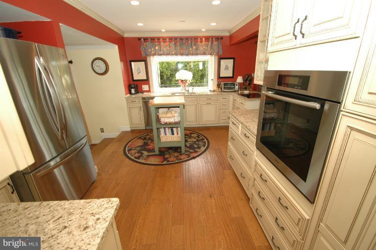 4331 Cub Run Road Chantilly, VA 20151 - Photo 9 of 30 a kitchen with stainless steel appliances granite countertop a refrigerator a stove and a sink with wooden floor