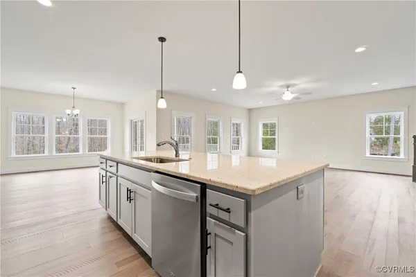 a kitchen with stainless steel appliances granite countertop a sink a counter space and a window