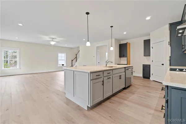a large kitchen with stainless steel appliances kitchen island a large counter top and a wooden floors
