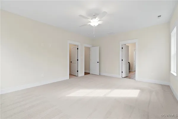 a view of an empty room with a ceiling fan