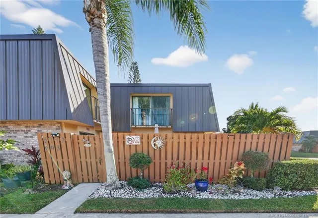 a view of a house with a small yard and wooden fence