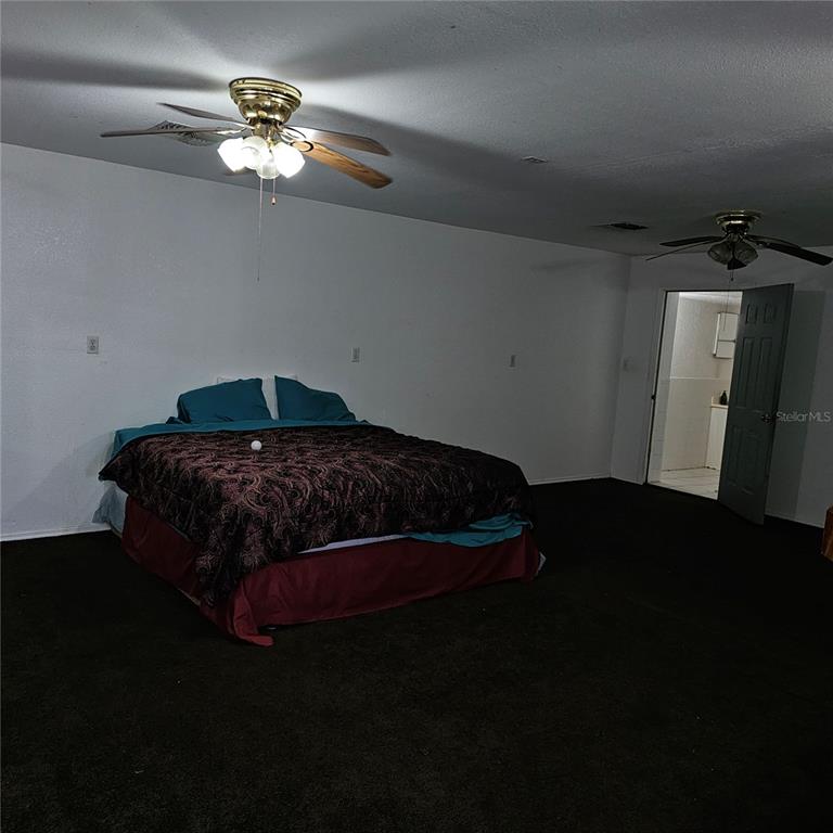 901 8th Street Southwest Ruskin, FL 33570 - Photo 13 of 27 a bedroom with a bed and a chandelier