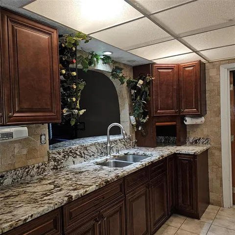 a bathroom with a granite countertop sink a mirror and shower