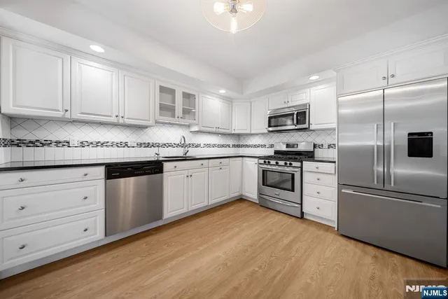 a kitchen with cabinets stainless steel appliances and a window