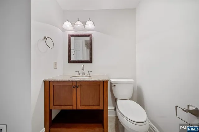 a bathroom with a toilet a sink and mirror