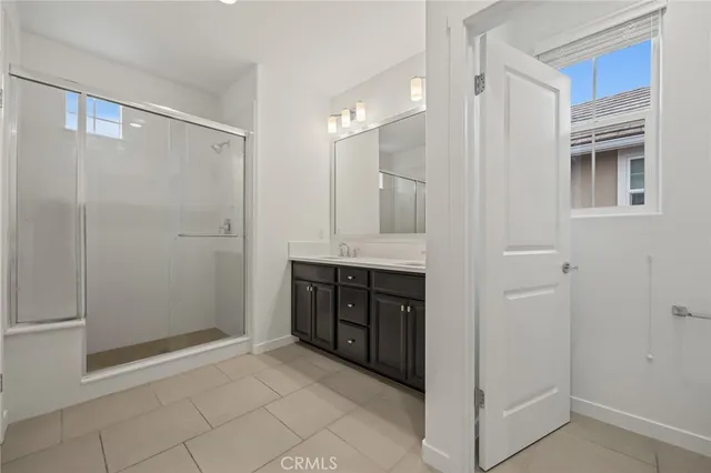 a bathroom with a double vanity sink a mirror and a shower