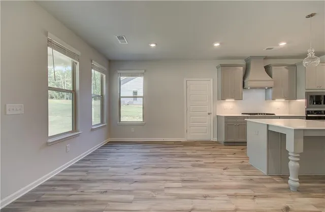 a kitchen with granite countertop a stove a sink and a refrigerator
