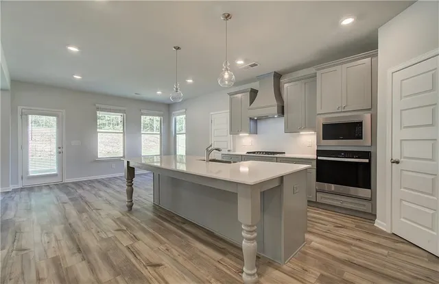 a large kitchen with cabinets wooden floor and stainless steel appliances