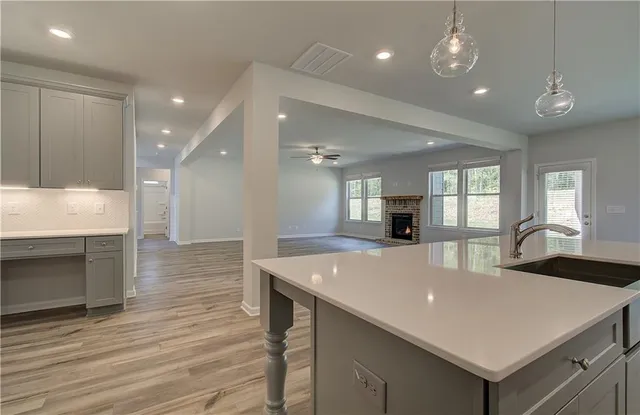 a large kitchen with kitchen island a sink granite counter tops and a fireplace