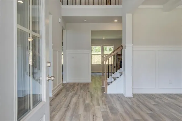 a view of a hallway with wooden floor and staircase