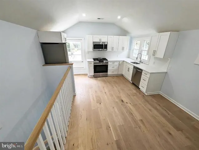 a view of kitchen with wooden floor and electronic appliances