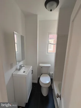a white toilet sitting next to a bathroom sink