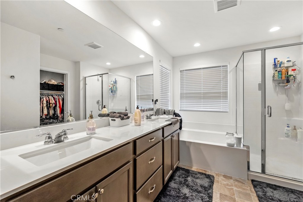 774 Green Court Perris, CA 92571 - Photo 14 of 25 a bathroom with a sink double vanity granite tub shower and a mirror