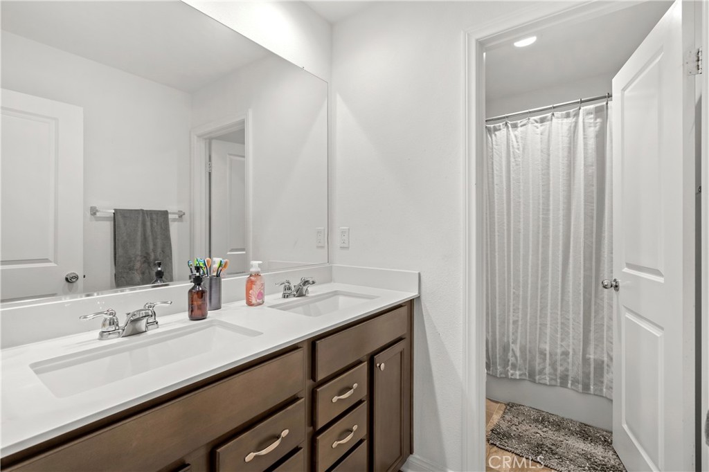 774 Green Court Perris, CA 92571 - Photo 17 of 25 a bathroom with a double vanity sink and a mirror