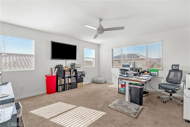 a view of a livingroom with workspace and a window
