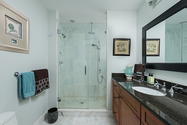 1506 Columbia Road, Unit 1 Boston, MA 02127 - Photo 17 of 24 a bathroom with a granite countertop sink a mirror a shower and a bathtub