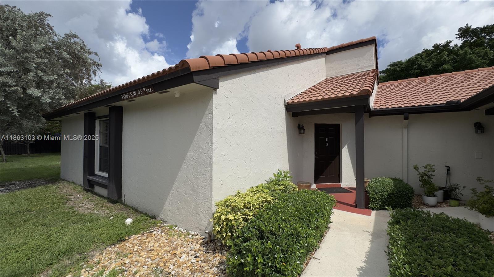 15205 Southwest 45th Terrace, Unit 45E Miami, FL 33185 - Photo 1 of 9 a front view of a house with garden