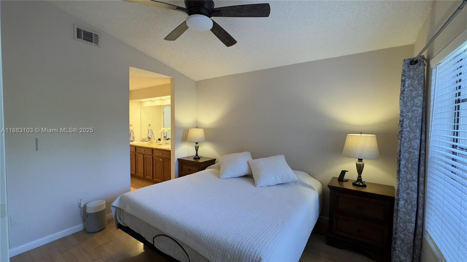 15205 Southwest 45th Terrace, Unit 45E Miami, FL 33185 - Photo 3 of 9 a bedroom with a bed and a lamp