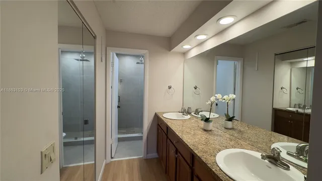 a bathroom with a granite countertop sink and a mirror