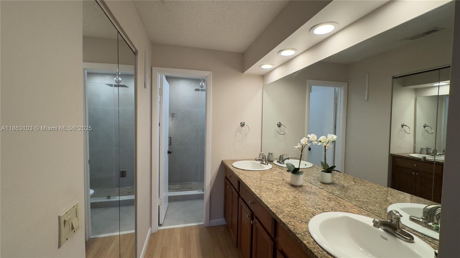 15205 Southwest 45th Terrace, Unit 45E Miami, FL 33185 - Photo 4 of 9 a bathroom with a granite countertop sink and a mirror