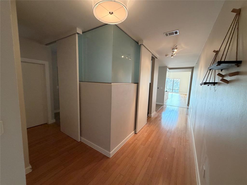 4040 North Hall Street, Unit 309 Dallas, TX 75219 - Photo 2 of 18 a view of hallway with wooden floor